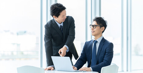 ノートパソコンを見ながら相談する2人の男性ビジネスマン, Two Male...