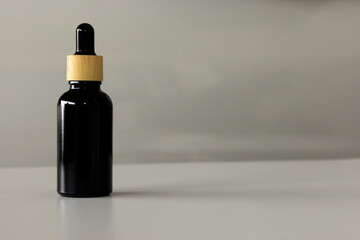 Minimal Black Cosmetic Serum Container on Neutral Surface