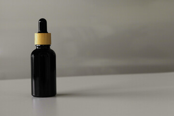 Minimal Black Cosmetic Serum Container on Neutral Surface