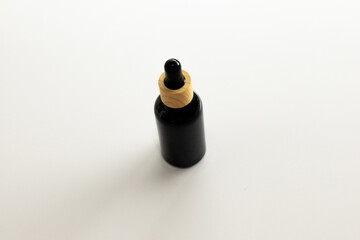 Minimal Black Cosmetic Serum Container on Neutral Surface