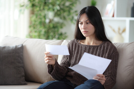 Worried asian woman reading bad news in a letter