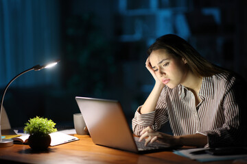 Worried tele worker in the night working online at home
