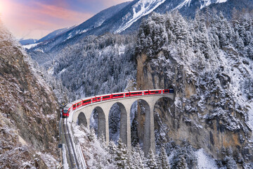 Train passes through snow-capped mountains in Filisur, Switzerland in the winter of the Swiss Alps.  © Sky view