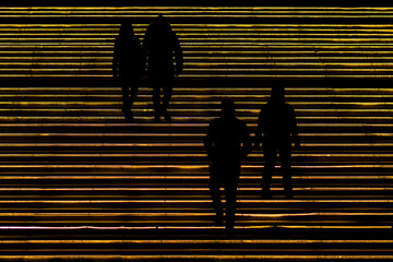 Silhouettes Walking on Illuminated Urban Steps at Night