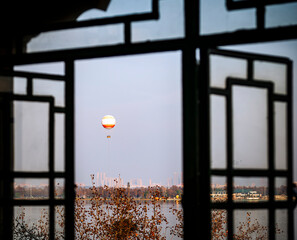 Hot Air Balloon Over East Lake Framed by Traditional Window in Wuhan China