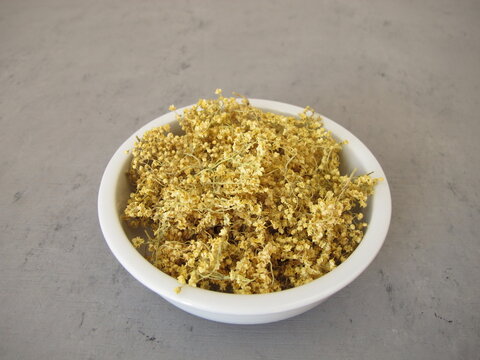 Dried elderflowers in a porcelain bowl for herbal tea - natural herbal remedy and traditional home medicine from black elder shrub
