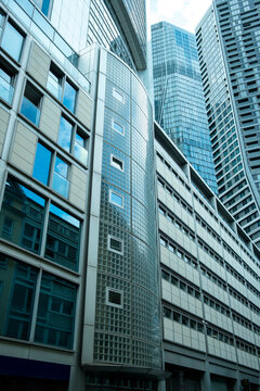 Modern glass office skyscraper architecture in Frankfurt Germany city along a street with strong perspective highlighting corporate urban scale and design