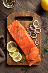 Fresh salted salmon with spices on cutting board