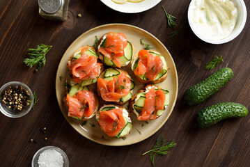 Smoked salmon toasts with cream cheese, fresh cucumber and greens
