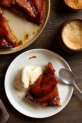 Slice of delicious apple tarte Tatin with sweet caramelized red apples and sugar caramel served with ice cream