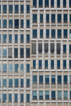Urban architecture detail of office building with windows on modern facade showing grid pattern repetition and corporate minimal texture background