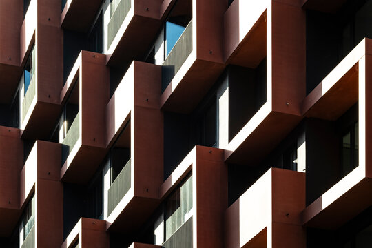 Urban architecture detail of balconies on modern building facade with geometry pattern and shadows delivering abstract rhythm in design background
