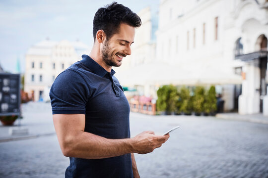 Smiling man using cell phone in the city