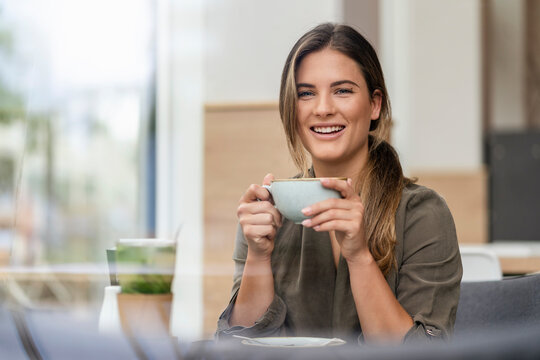 Young businesswoman with coffee cup in a cafe
