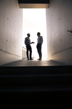 Two businessmen talking in a passageway