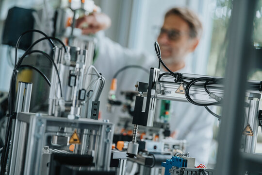 Close-up of machinery with male scientist in background at factory