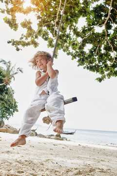 Thailand, Phi Phi Islands, Ko Phi Phi, smiling little girl on a rope swing on the beach