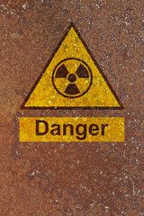 Obraz premium Danger radiation symbol sign on a rust background. Hazardous radiation danger risk concept.