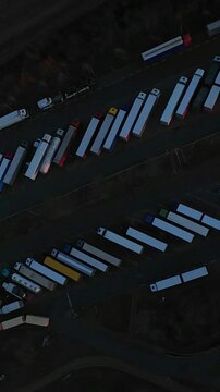 Vertical Screen Aerial View Of Convoy Reroute At Terminal Showing Trailers Shifting Lanes And Coordinated Movement, Dynamic Depot Scene With Vehicles Navigating Constrained Lanes, Urgency