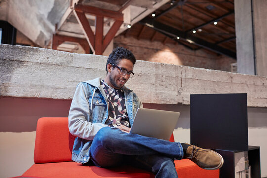 Young man working in creative start-up company, using laptop