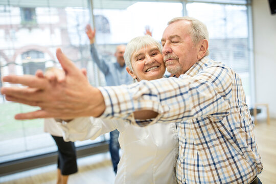 Group of active senior attending dance course in retirement home