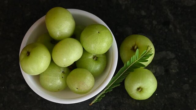 Phyllanthus emblica thai fruit herb. Amla (Phyllanthus emblica) fruits in white bowl on black background