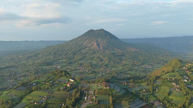 Mount batur volcano and lush green rice fields in bali, indonesia