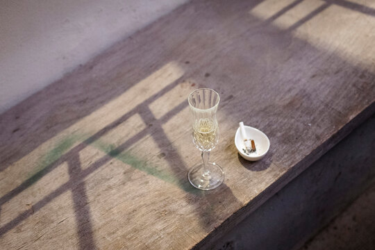 Calice di prosecco e sigarette spente nel posacenere.