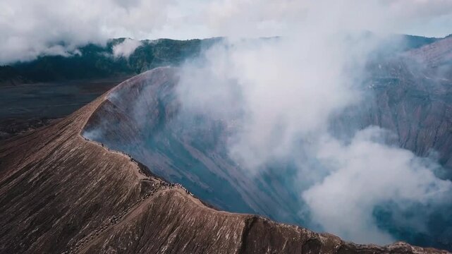 Aerial view of volcanic crater surrounded by clouds