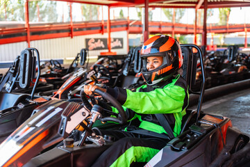 Fototapeta premium Young woman enjoying karting at race track