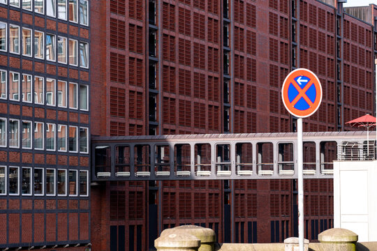 Daylight street scene of urban architecture with brick skybridge and sign in Speicherstadt Hamburg Germany near canal warehouses district