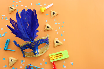 Purim celebration concept (jewish carnival holiday) over yellow background