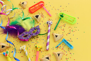 Purim celebration concept (jewish carnival holiday) over yellow background