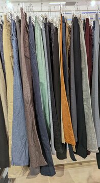 Pantalones vaqueros de varios colores en perchero de tienda de ropa