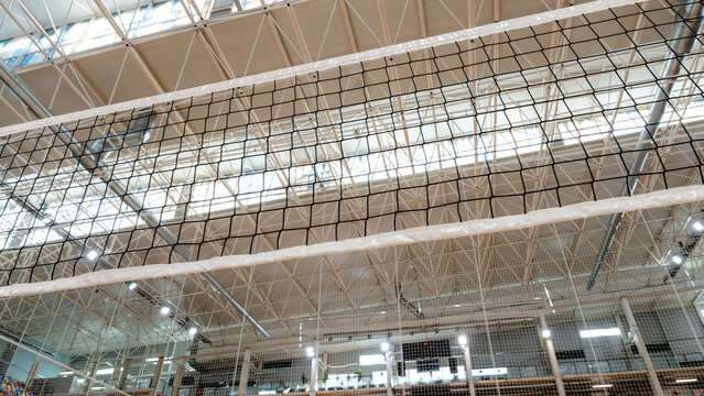Indoor gym with volleyball net and ceiling architecture