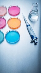 Laboratory pipette, colorful petri dishes filled with growing culture media, and a beaker with liquid on a metallic surface for medical research.