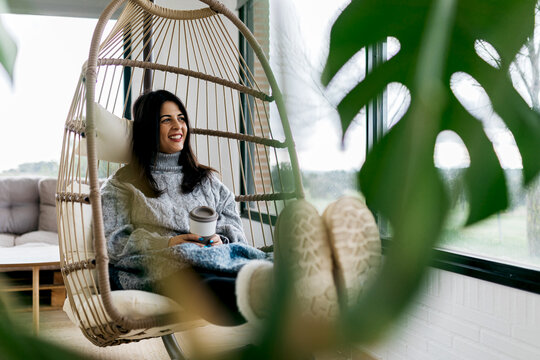 Cozy relaxation in a hanging chair by the window