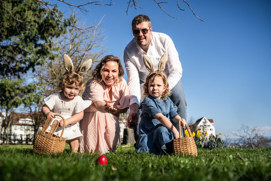 Family enjoying Easter egg hunt in the springtime