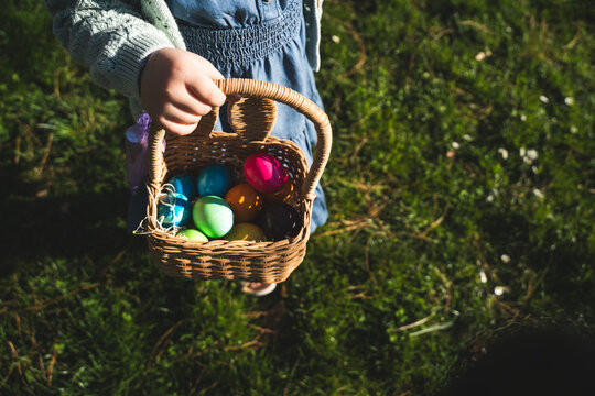 Girl holding basket of colorful Easter eggs