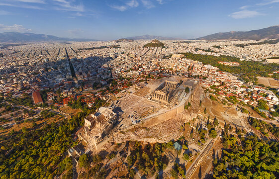 Aerial view of the majestic Acropolis standing proud amidst the sprawling urban landscape with the Parthenon gleaming under the sunlight, Athens, Central Athens Regional Unit, Greece.