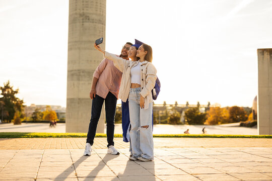 Friends capturing graduation memories with a selfie
