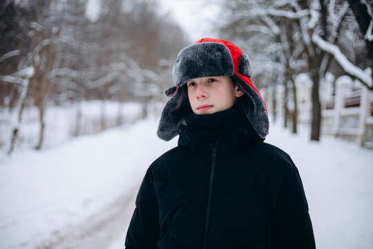 Teenage boy in snow with red winter hat