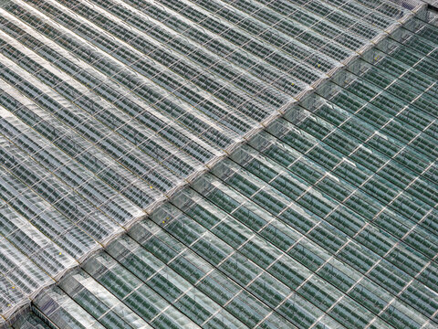 Aerial view of a glass roof with a symmetrical pattern reflecting the sky above, Plouguerneau, Bretagne, France.