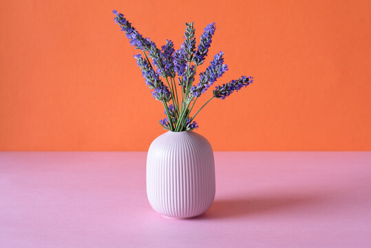 Lavender bouquet in vase against vibrant background