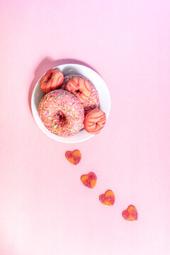 Pink donuts and heart candies on a pastel background