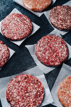 Raw veal burger patties on parchment paper