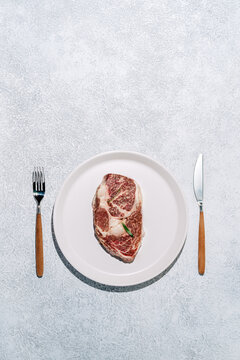Premium wagyu ribeye steak on white plate setting