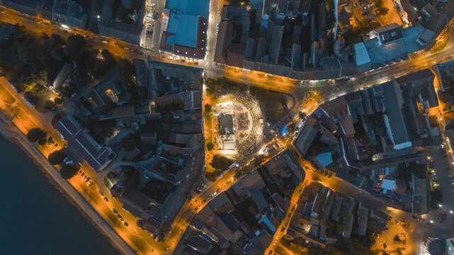 Aerial view of vibrant illuminated streets converging on a central plaza, a mesmerizing display of urban elegance at night, Sremska Mitrovica, Vojvodina, Serbia.