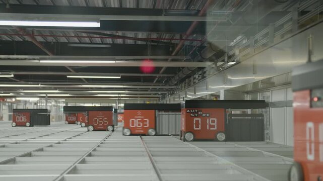 Footage of Autostore robots driving over a storage grid inside a fully automated warehouse system.