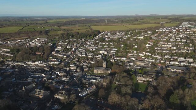 Aerial view of town nestled amid green fields, the church spire standing tall, the houses closely packed together, Bodmin, England, United Kingdom.